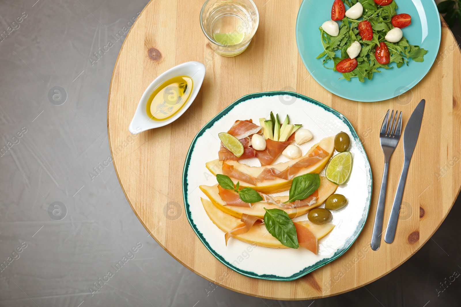 Photo of Flat lay composition with melon and prosciutto appetizer served on wooden table