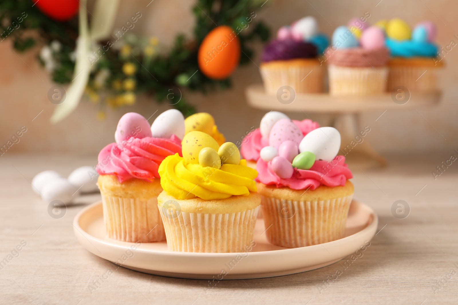 Photo of Tasty decorated Easter cupcakes on wooden table, closeup