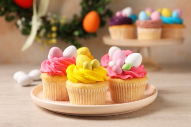 Photo of Tasty decorated Easter cupcakes on wooden table, closeup