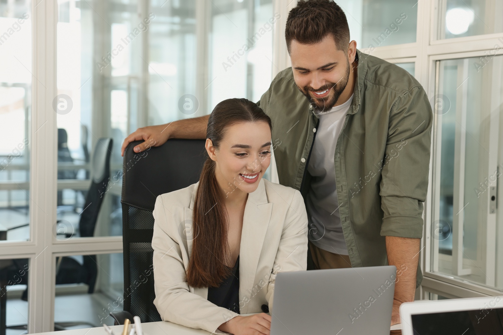 Photo of Colleagues working together in open plan office