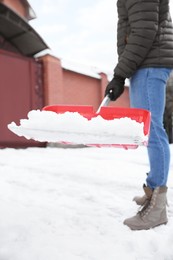 Photo of Person shoveling snow outdoors on winter day, closeup