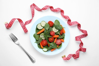 Measuring tape, salad and fork on white background, flat lay