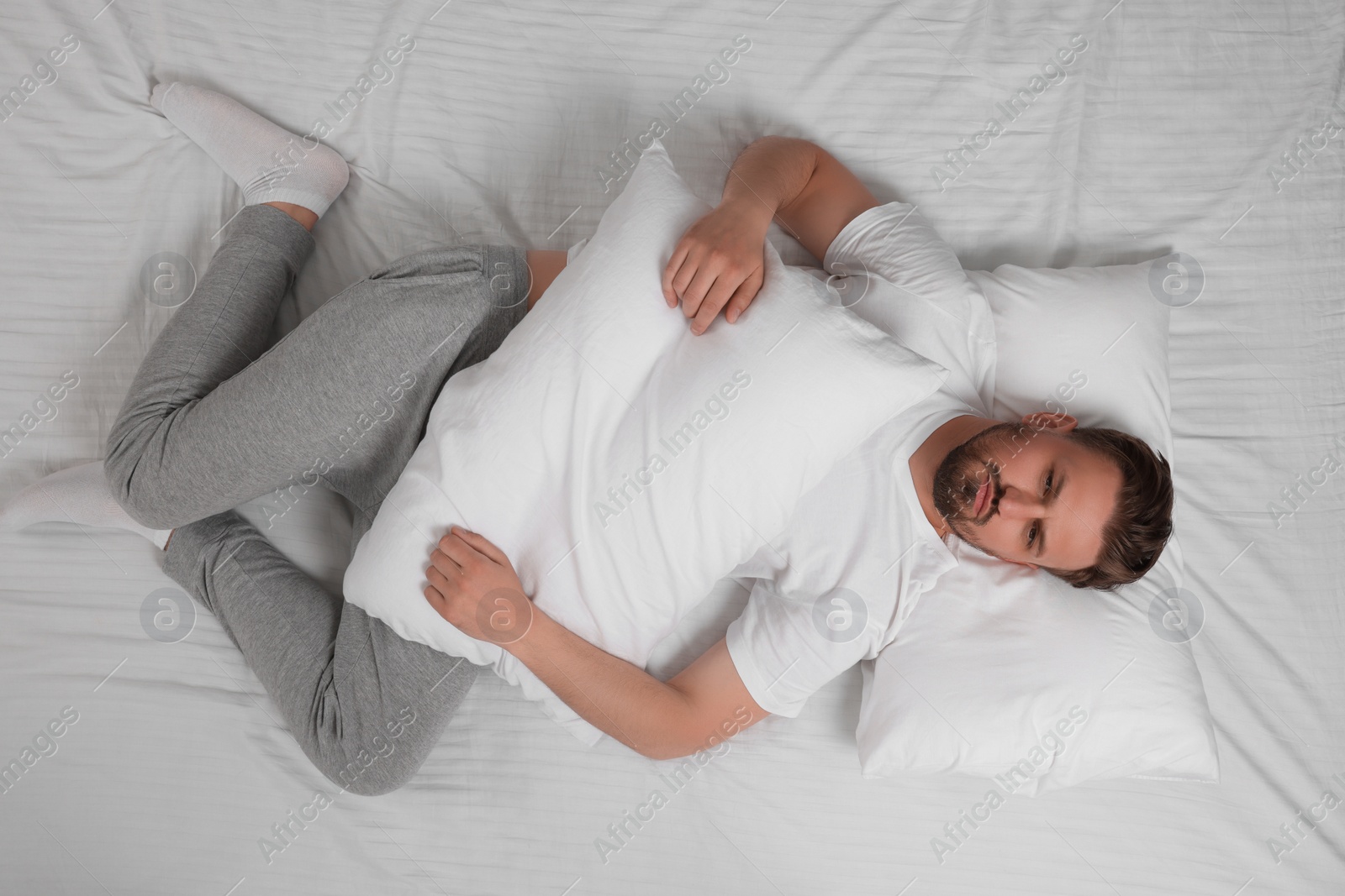 Photo of Man suffering from insomnia in bed, top view