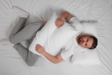 Man suffering from insomnia in bed, top view