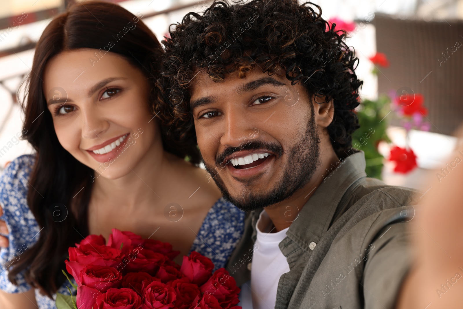 Photo of International dating. Happy couple taking selfie in restaurant