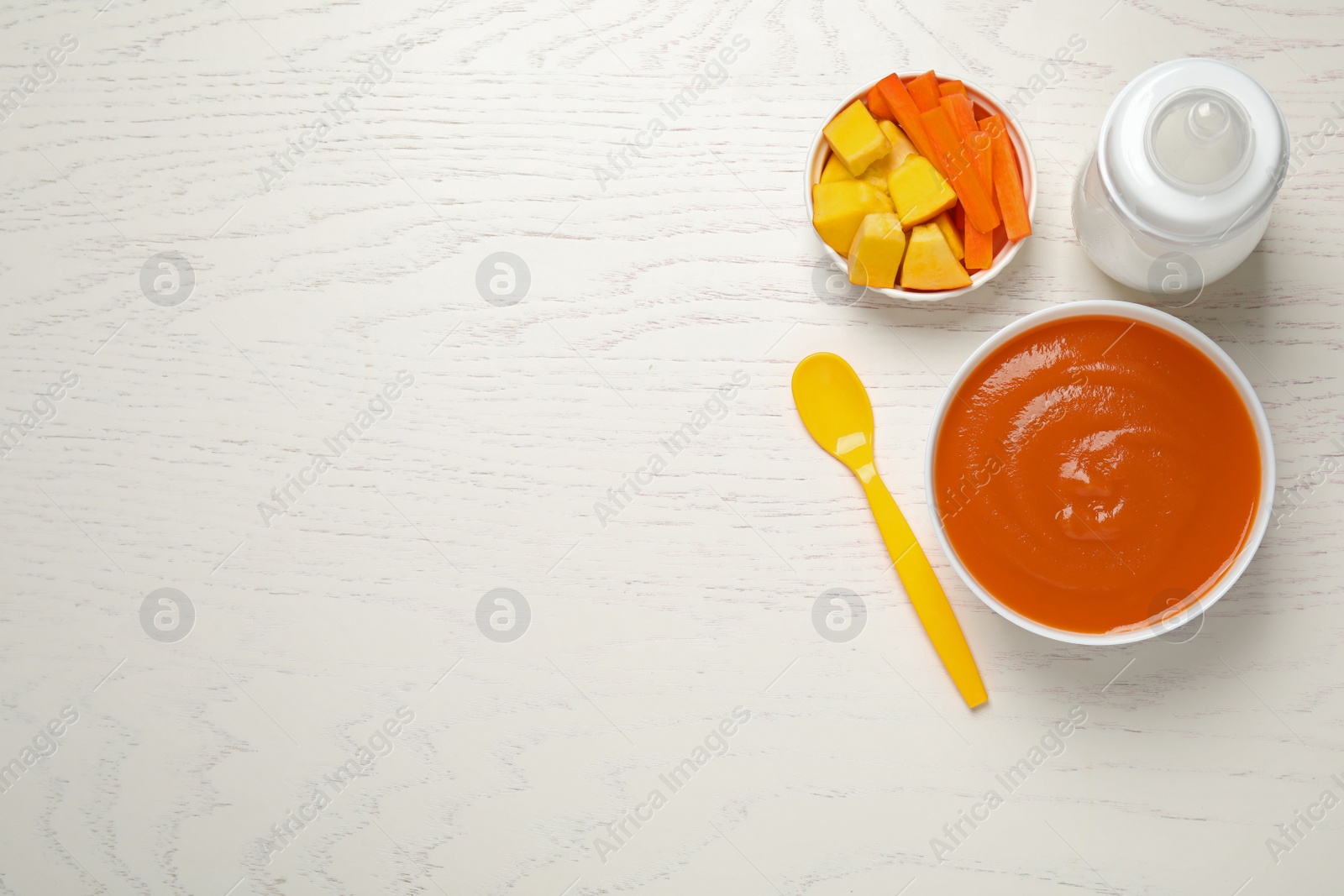 Photo of Healthy baby food and ingredients on white wooden table, flat lay. Space for text