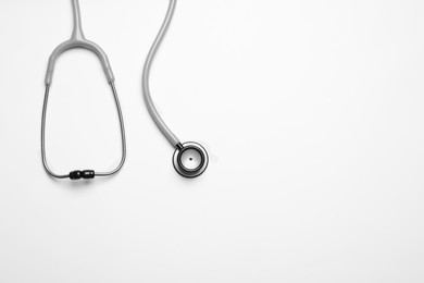 Stethoscope on white background, top view. Space for text