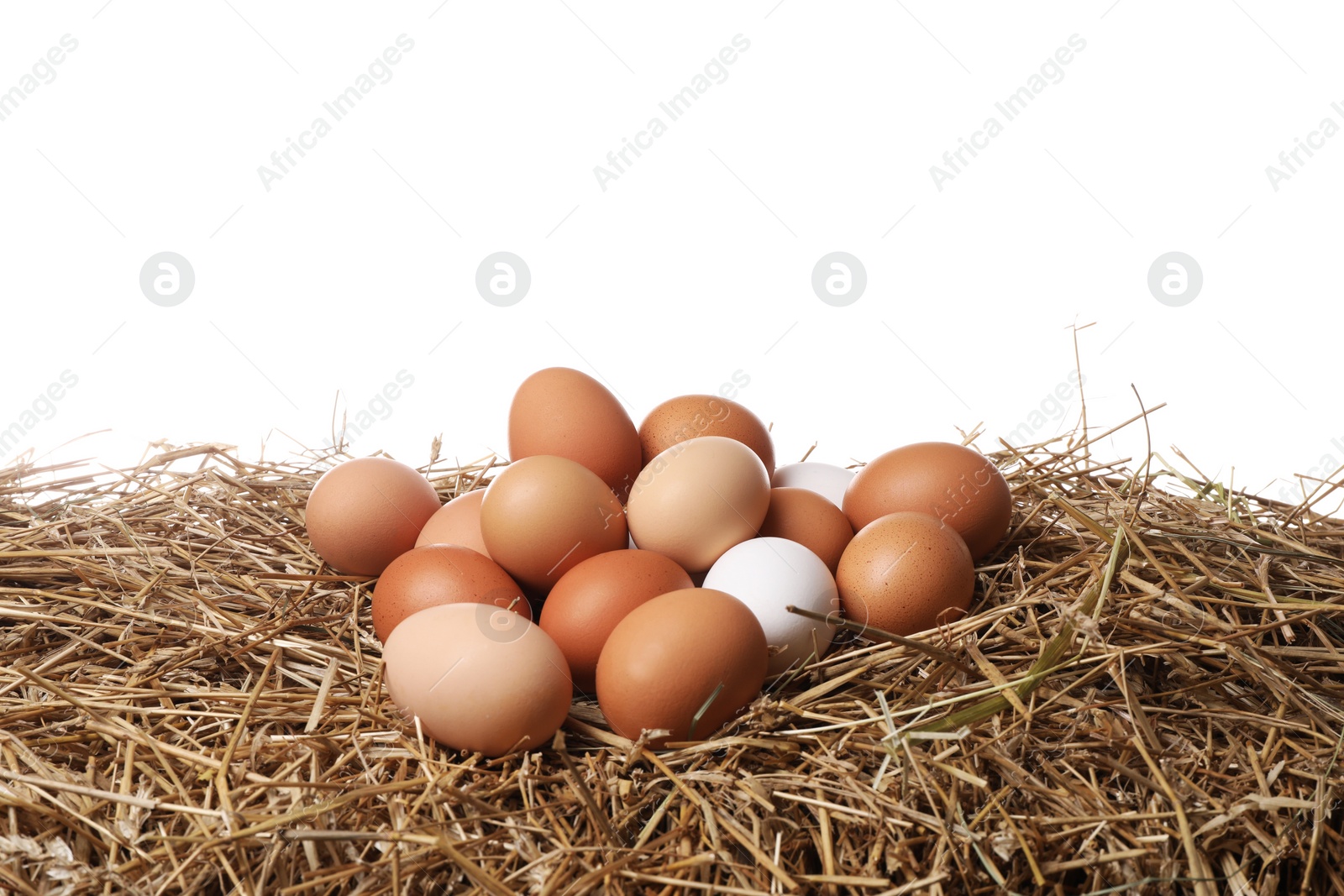 Photo of Fresh chicken eggs on dried straw against white background