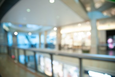 Blurred view of shopping mall with different stores, bokeh effect