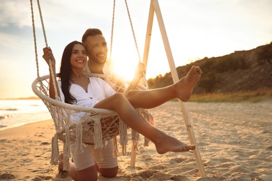 Happy young couple on beach at sunset