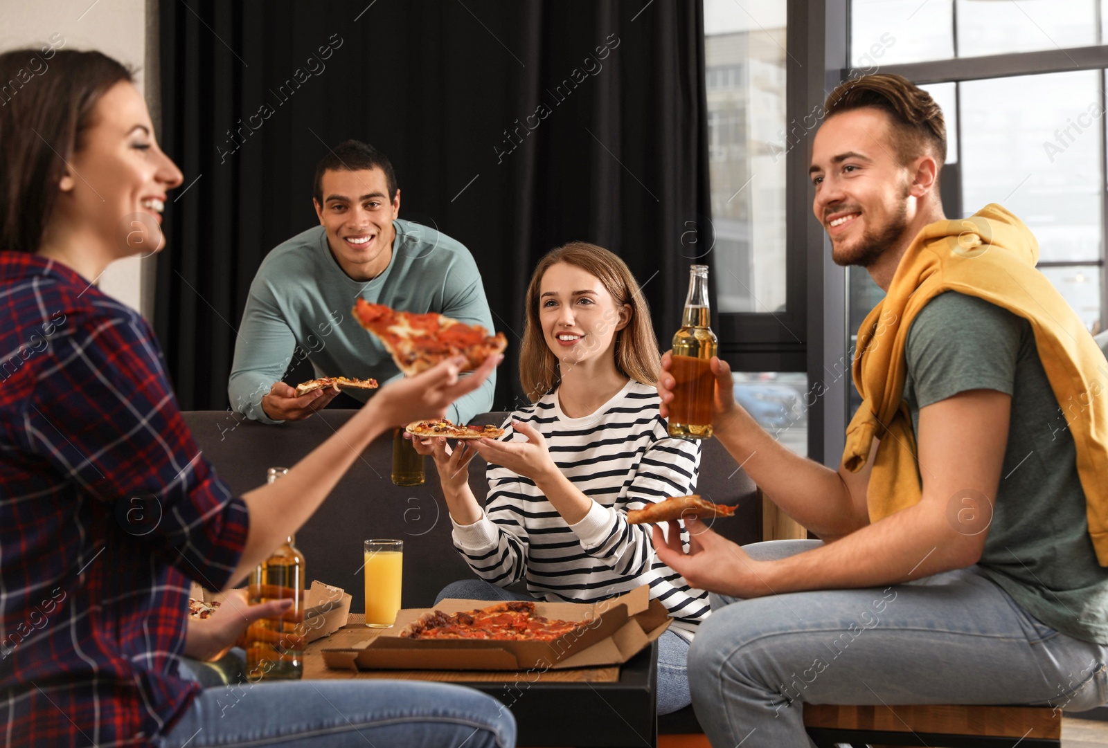 Photo of Group of friends having fun party with delicious pizza in cafe