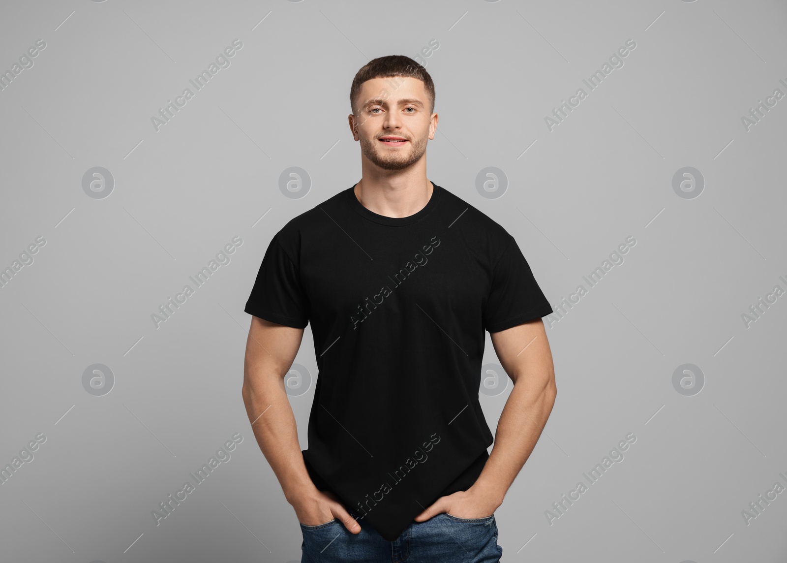 Photo of Man wearing black t-shirt on light grey background. Mockup for design