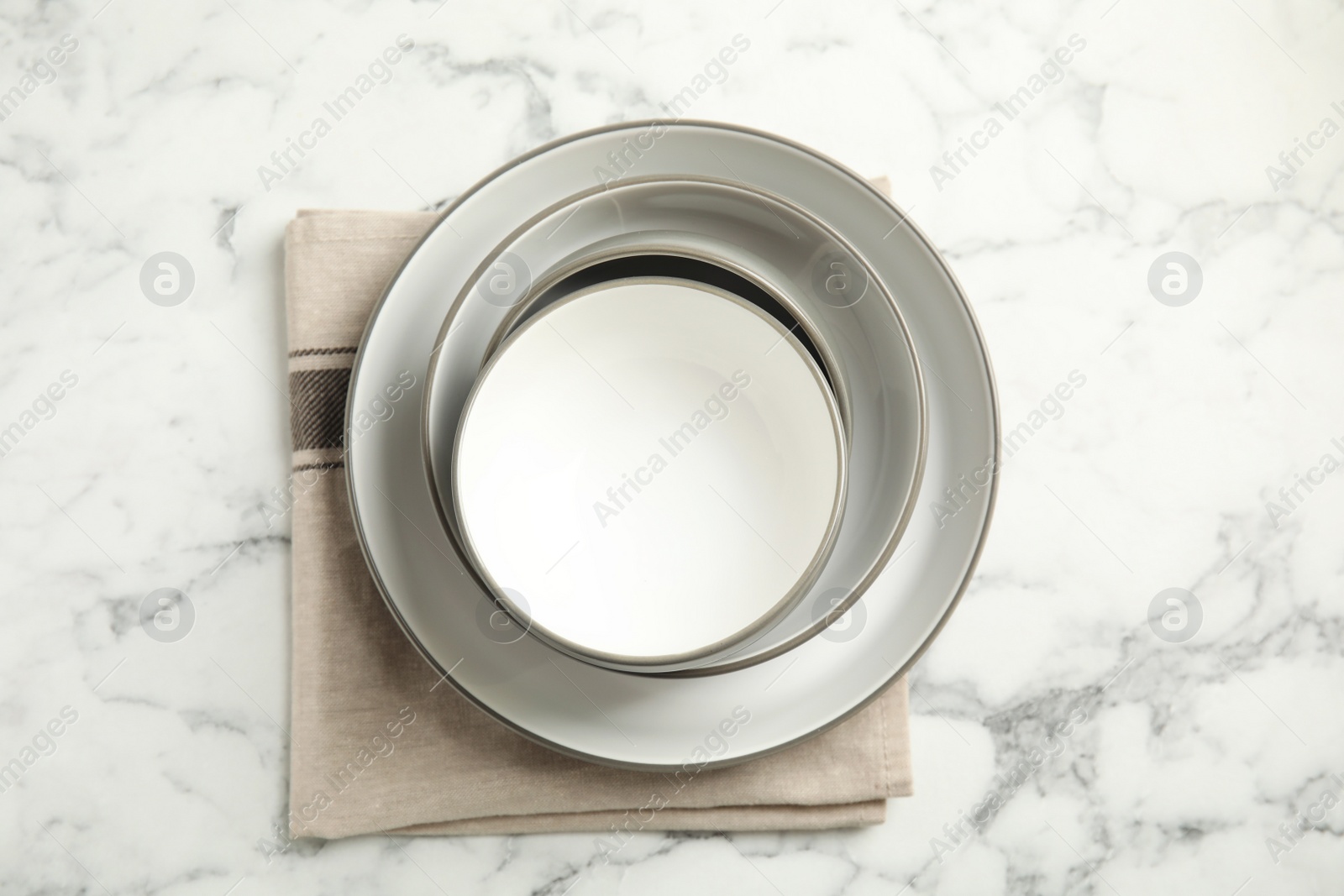 Photo of Set of clean dishware on white marble table, flat lay