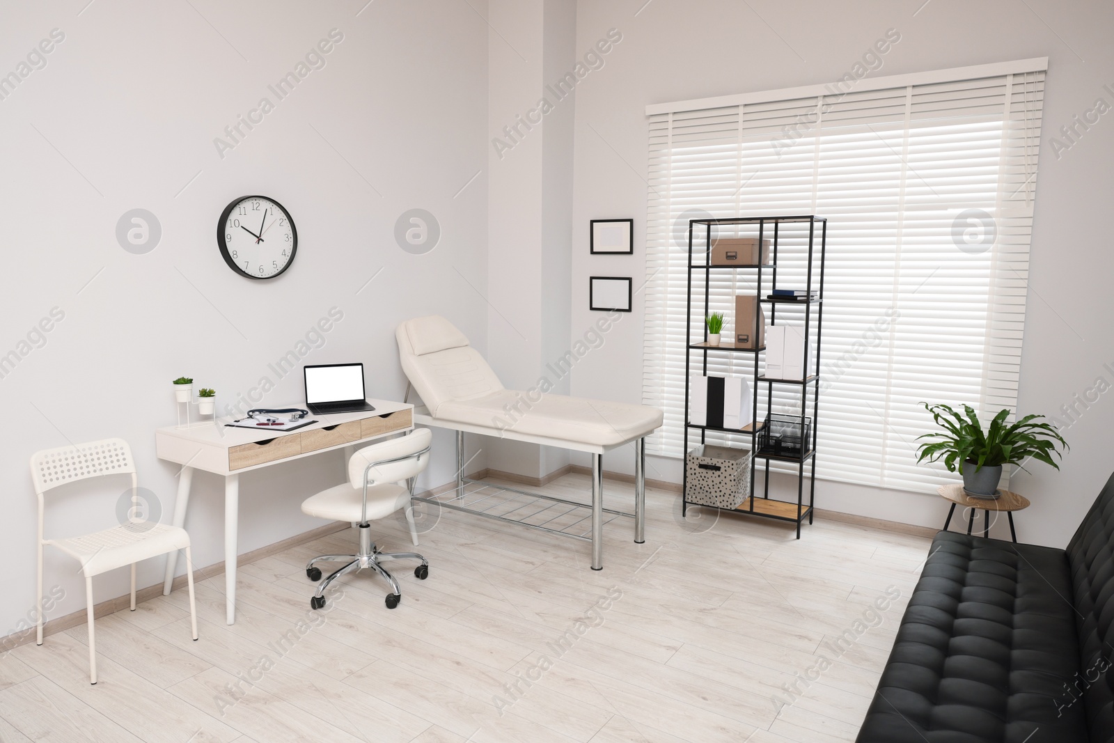 Photo of Modern medical office with doctor's workplace and examination table in clinic