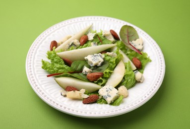 Photo of Delicious pear salad on green background, closeup