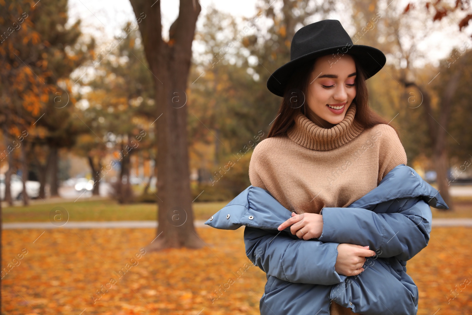 Photo of Young woman wearing stylish clothes in autumn park, space for text