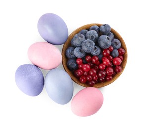 Photo of Naturally painted Easter eggs on white background, top view. Blueberries and cranberries used for coloring