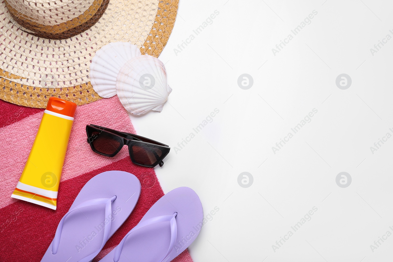 Photo of Flat lay composition with sunscreen and beach accessories on white background. Space for text