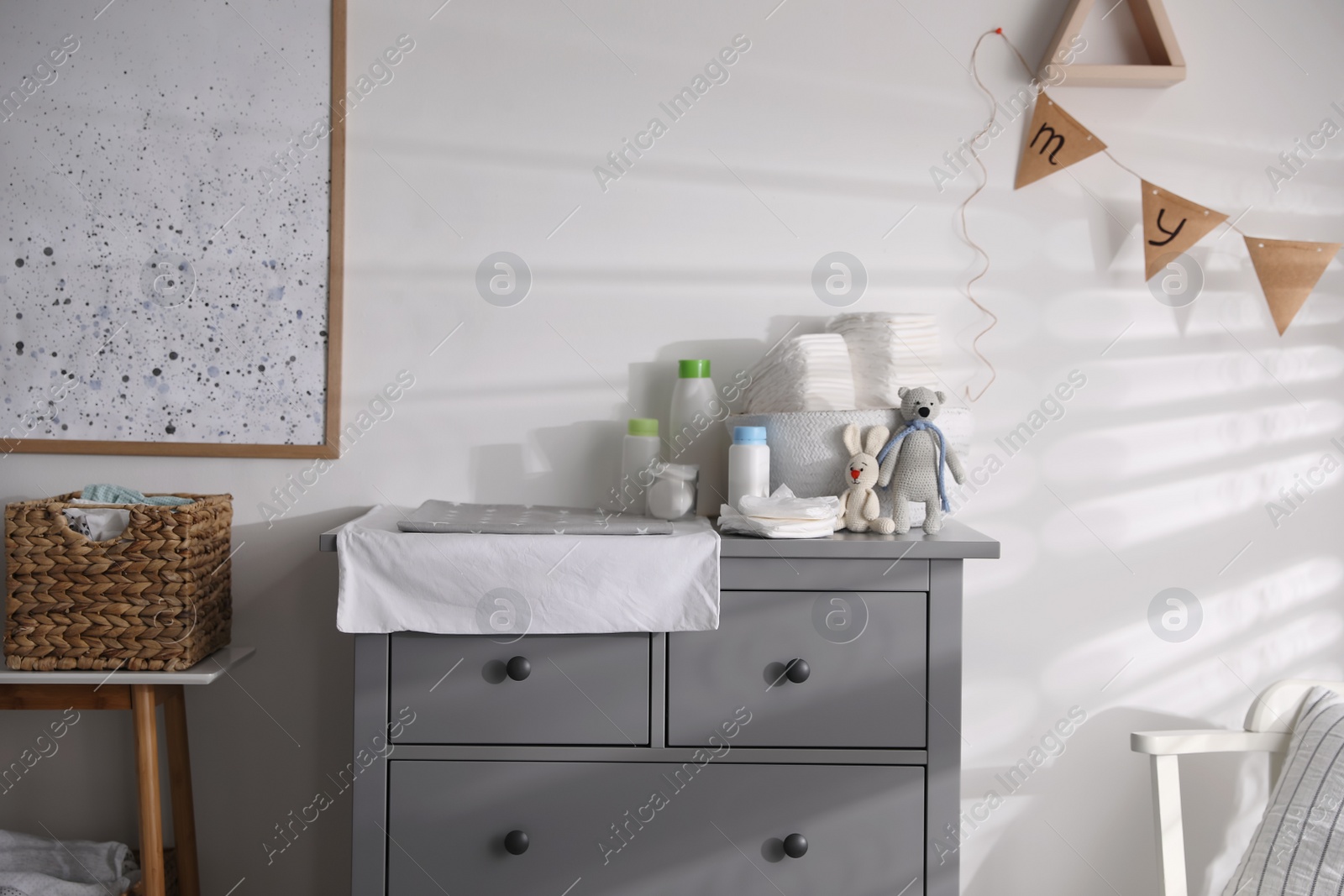 Photo of Chest of drawers with changing place in baby room. Interior design