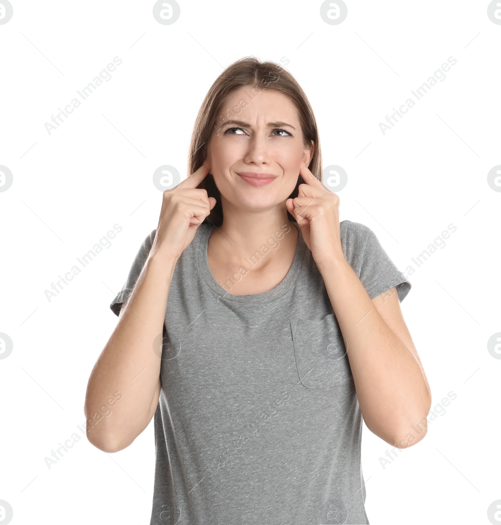 Photo of Emotional young woman covering her ears with fingers on white background