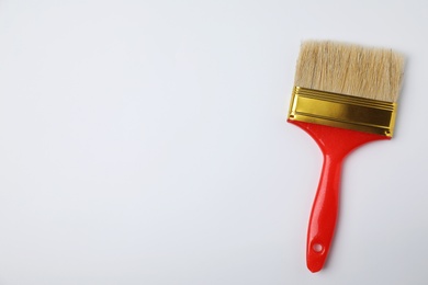 Photo of Paint brush on color background, top view. Space for text