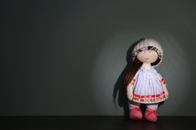 Abandoned doll on table against gray background. Time to visit child psychologist