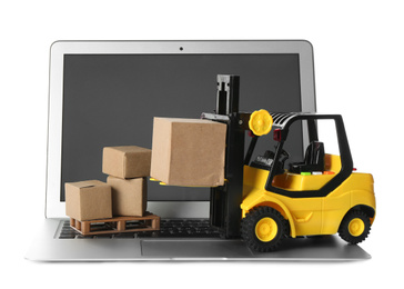 Photo of Laptop, forklift model and carton boxes on white background. Courier service
