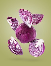 Image of Fresh whole and cut red cabbages falling on olive color background