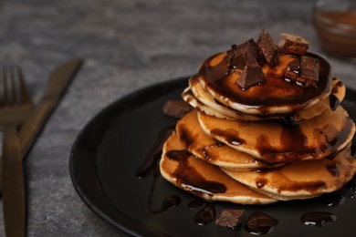 Tasty pancakes with chocolate on table