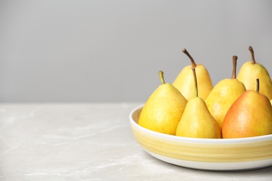 Photo of Plate with pears on table against grey background. Space for text