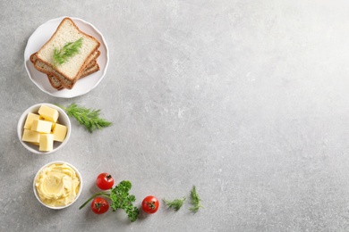 Photo of Flat lay composition with bread and butter on grey background. Space for text