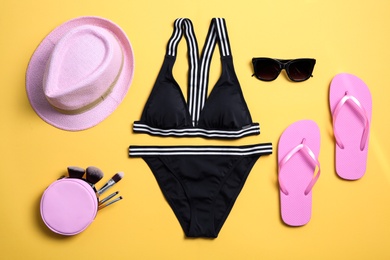 Photo of Flat lay composition with bikini and accessories on color background