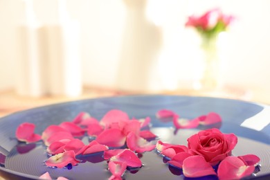 Photo of Pink roses and petals in bowl with water, closeup