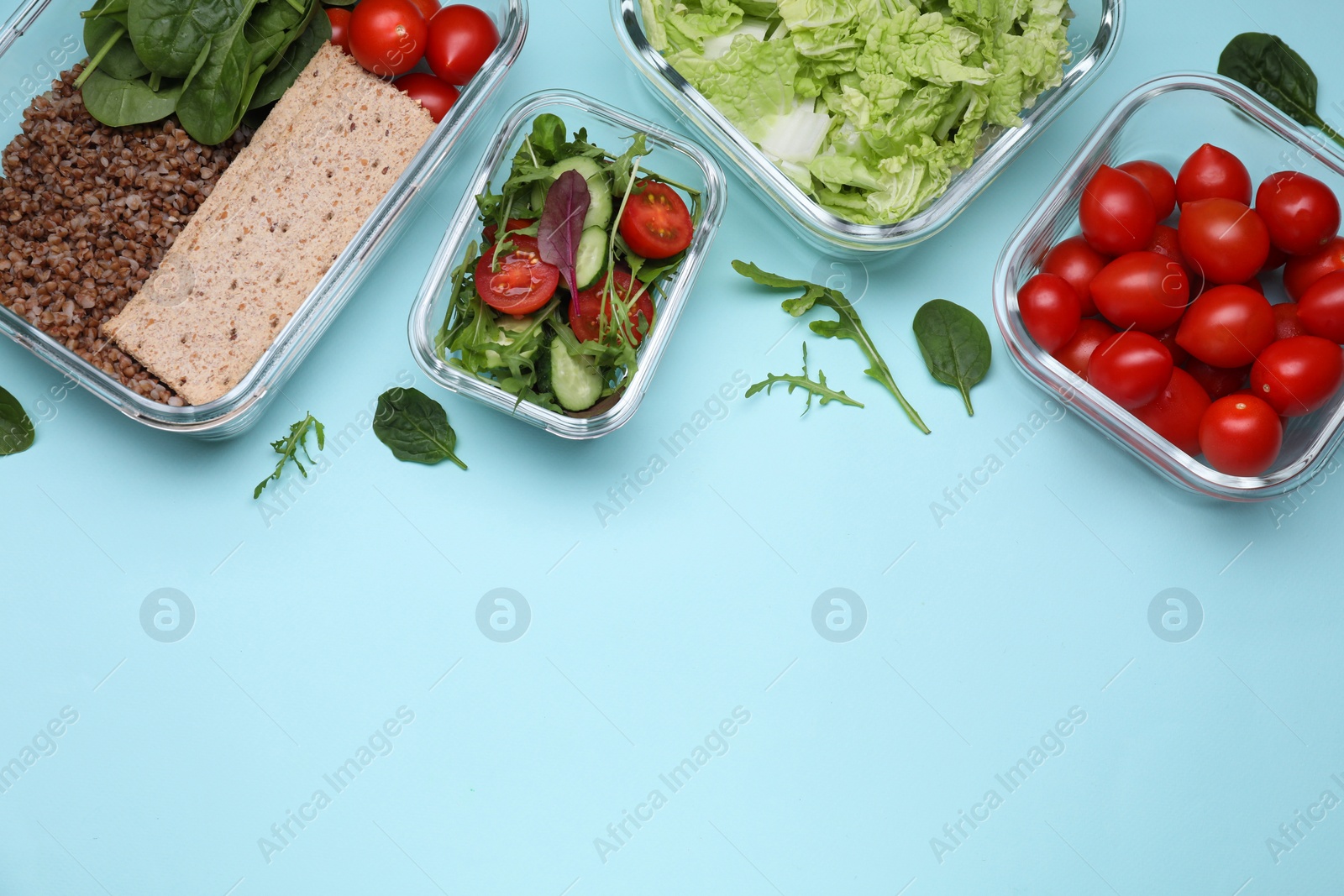 Photo of Glass containers with different fresh products on light blue background, flat lay. Space for text