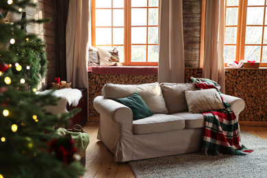 Photo of Festive interior with comfortable sofa and decorated Christmas tree