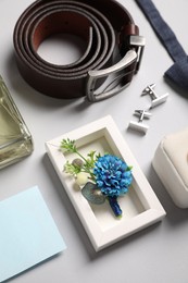 Photo of Wedding stuff. Composition with stylish boutonniere on light gray background, above view