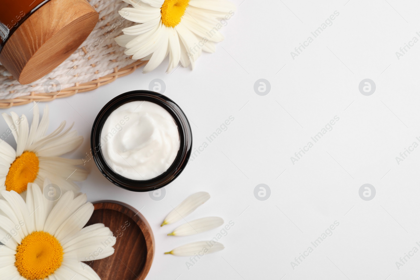 Photo of Flat lay composition with jar of face cream and beautiful flowers on white background. Space for text