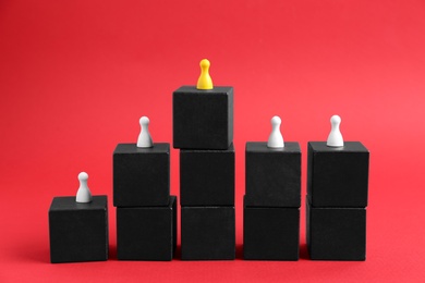 Photo of Black blocks with playing pieces on red background. Roles and responsibility concept