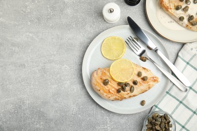 Photo of Delicious chicken fillet with capers and lemon served on light grey table, flat lay. Space for text