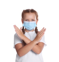 Photo of Little girl in protective mask showing stop gesture on white background. Prevent spreading of coronavirus