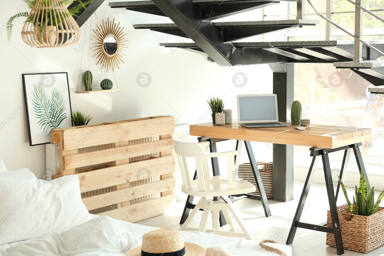 Photo of Elegant interior of bedroom with workplace under stairs