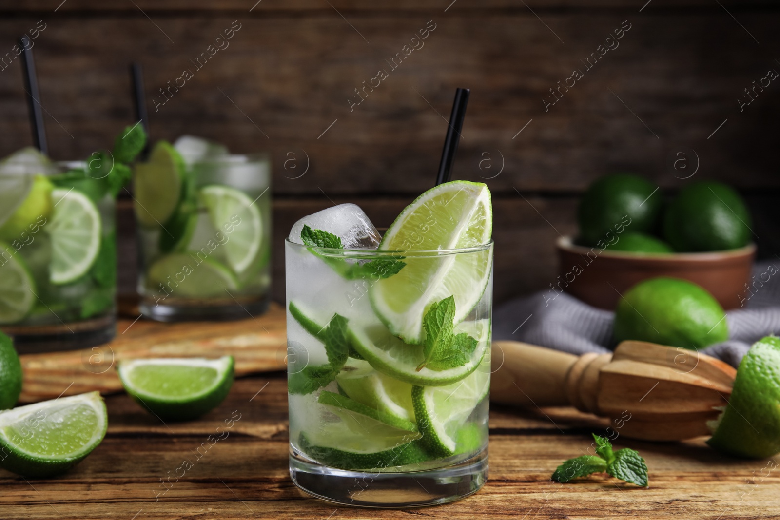 Photo of Delicious mojito and ingredients on wooden table
