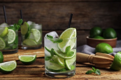 Photo of Delicious mojito and ingredients on wooden table