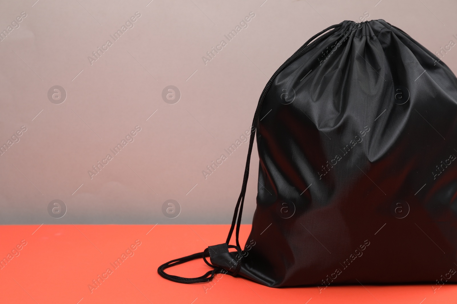 Photo of One black drawstring bag on grey background, closeup. Space for text