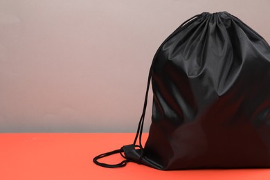 Photo of One black drawstring bag on grey background, closeup. Space for text