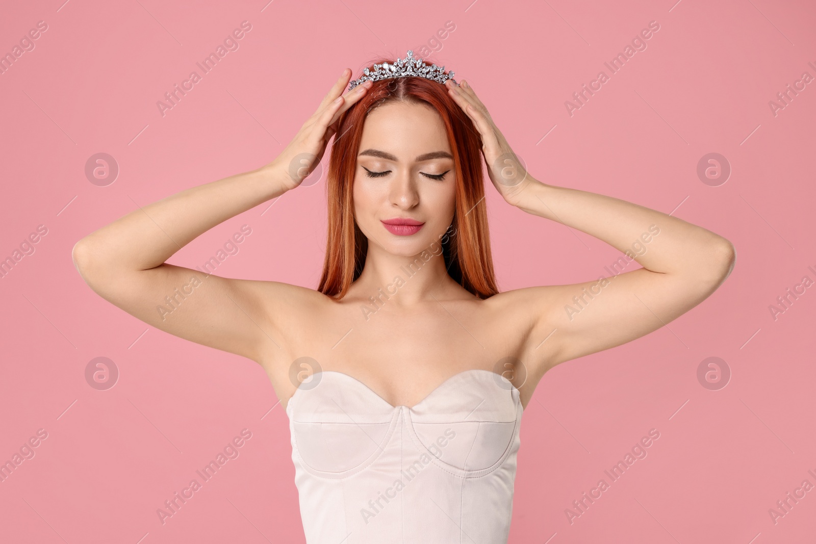 Photo of Beautiful young woman with tiara on pink background