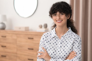 Photo of Portrait of beautiful woman with curly hair indoors. Attractive lady smiling and looking into camera. Space for text