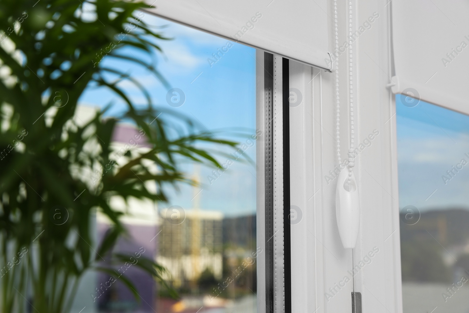 Photo of Window with white roller blinds indoors, closeup