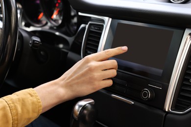 Photo of Woman using navigation system while driving her car, closeup