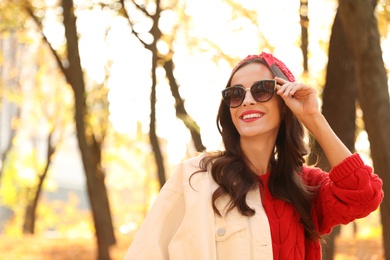 Photo of Beautiful woman wearing sunglasses in park. Autumn walk